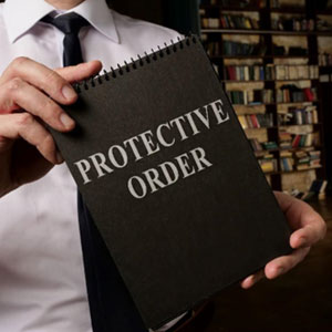Man holding a "protective order" notebook - Tim Hendrix Attorney At Law, PLLC
